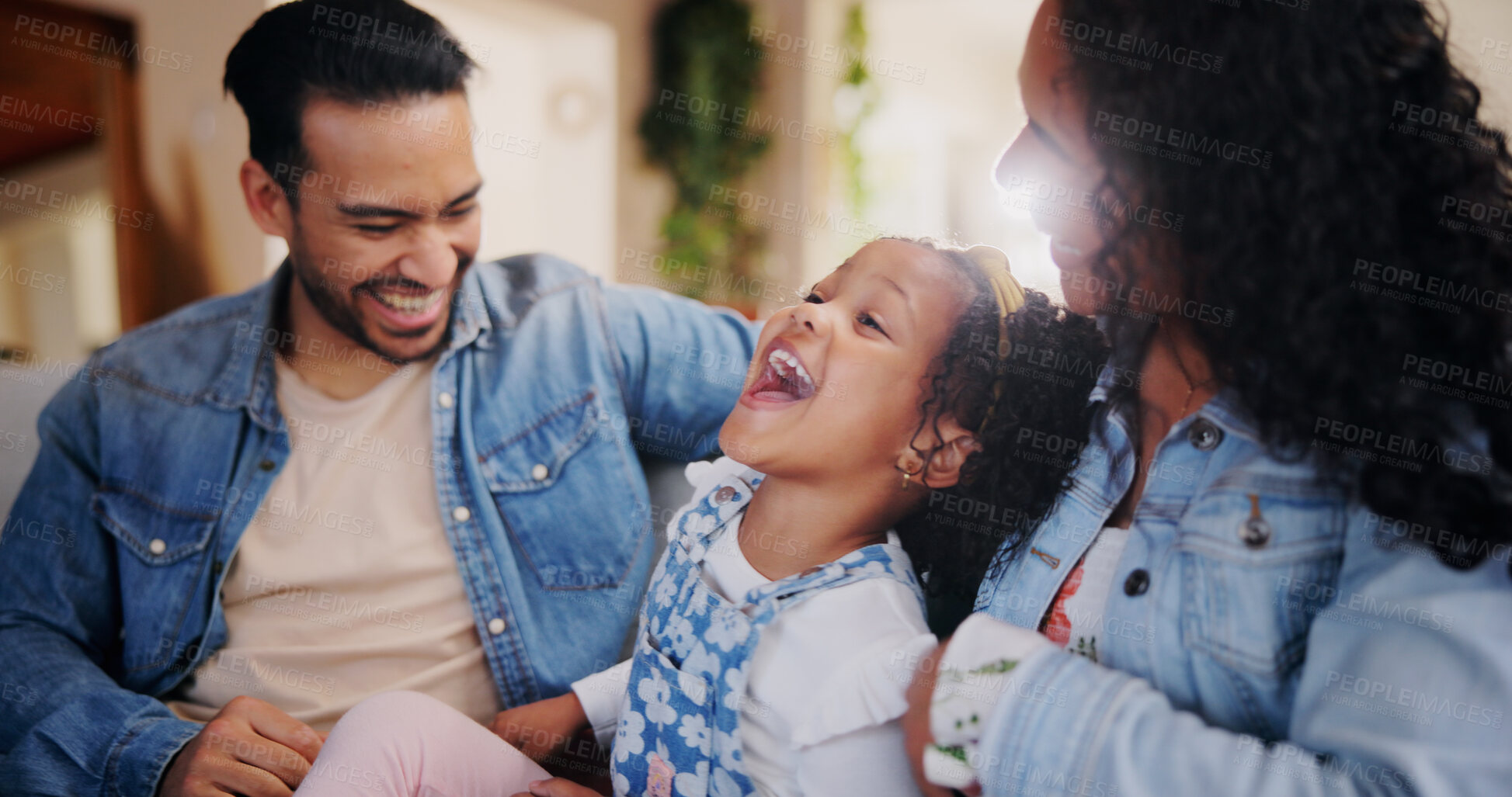 Buy stock photo Parents, girl and tickle on sofa, laugh and bonding with love, comic joke and relax in lounge at family house. People, mother and father with child, care and funny games in living room at apartment