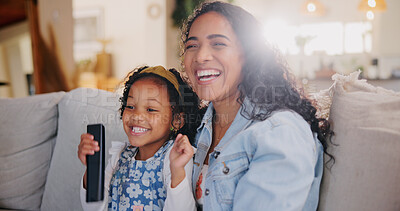Buy stock photo Mom, girl and happy for watching tv on couch with remote control for movie, hug or bonding with love. Child, mother and daughter with smile, care or laugh on sofa for streaming film in family home