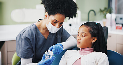 Buy stock photo Dentist, girl and mold with teaching for oral wellness, care and listening to advice at hospital. Woman, child and dental model for learning, talk and consultation for health services at clinic