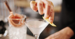 Cocktail, cafe and hands of barman with glass, lemon and tools for artisan beverage recipe. Mixology, small business pub and person at counter with happy hour drinks, martini process or craft alcohol