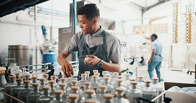 Buy stock photo Distillery, worker and sealing bottle in factory for alcohol production process, packaging and spirits storage. Assembly line, man and cork drink by machine for beverage supply and quality control