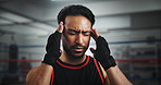 Man, headache and stress at gym for boxing by ring for fighter, fatigue and concussion at training center. Person, migraine and athlete with pain, mixed martial arts and vertigo at fitness club