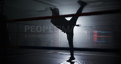 Buy stock photo Person, silhouette and kick in ring at gym, training and power with routine for combat sports. Athlete, fighter and mixed martial arts with workout, exercise and ready for competition at fitness club