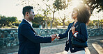 Business people, city and handshake with meeting for partnership, greeting or introduction. Businessman, woman or colleagues shaking hands with smile at outdoor park for opportunity in an urban town
