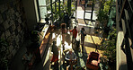 Above, business trip and people in lobby of hotel for checkin, arrival or reception desk. Hospitality, men and women at entrance of travel accommodation with luggage, service or handshake for welcome