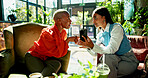 Phone, business women and discussion in cafe for idea, brainstorming or show eco friendly project online. Mobile, team meeting and planning in coffee shop for proposal with sustainability consultant