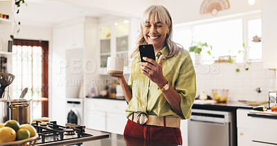 Buy stock photo Coffee, phone and smile of woman in kitchen of home for break, communication or wellness. App, reading and social media with happy senior person drinking caffeine beverage in apartment for retirement