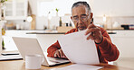 Senior man, documents and taxes with stress in home, reading and financial review for pension. Elderly person, laptop and thinking with budget, bills and confused with retirement income in kitchen