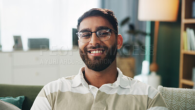 Buy stock photo Portrait, glasses and happy man in home for relax, peace and calm on weekend break in apartment. Smile, living room and male person on sofa with comfort, resting and chill with confidence in UAE