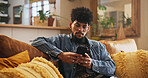 Man, relax and typing with phone in home for mobile chat, reading online news and internet browsing. Person, connection and smartphone on sofa for streaming subscription, social media or playing game