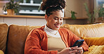 Girl, smile and typing with phone on sofa for dating site, mobile chat or reading online news. Gen z person, relax or happy with smartphone in home for streaming service, social media or app download