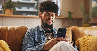 Buy stock photo Man, smile and typing with phone on sofa for dating site, text message or reading online news. Gen z person, relax or happy with smartphone in home for streaming service, social media or playing game