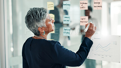 Buy stock photo Mature woman, writing or brainstorming with glass board for schedule planning at office. Female person, planner or employee taking notes with mindmap idea for strategy, reminder or tasks at workplace