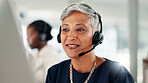Happy, mature woman or consultant with headset on computer for online adivce or customer service. Female person, agent or employee talking with mic or technology for virtual assistance at call center