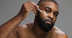 Serum, skincare and portrait of black man in studio for salon, grooming and dermatology. Cosmetics, glow and self care with person and oil dropper on gray background for hydration, hygiene and shine