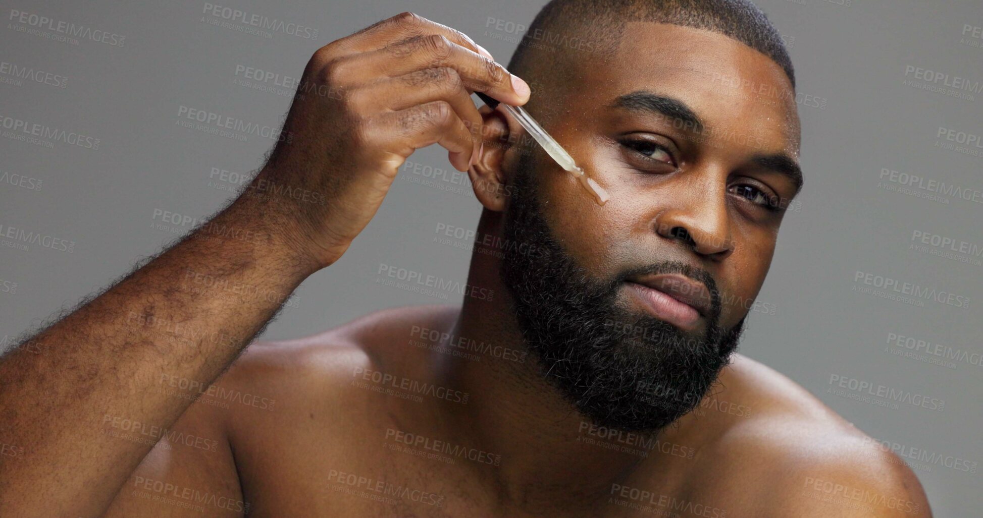 Buy stock photo Serum, skincare and portrait of black man in studio for salon, grooming and dermatology. Cosmetics, glow and self care with person and oil dropper on gray background for hydration, hygiene and shine