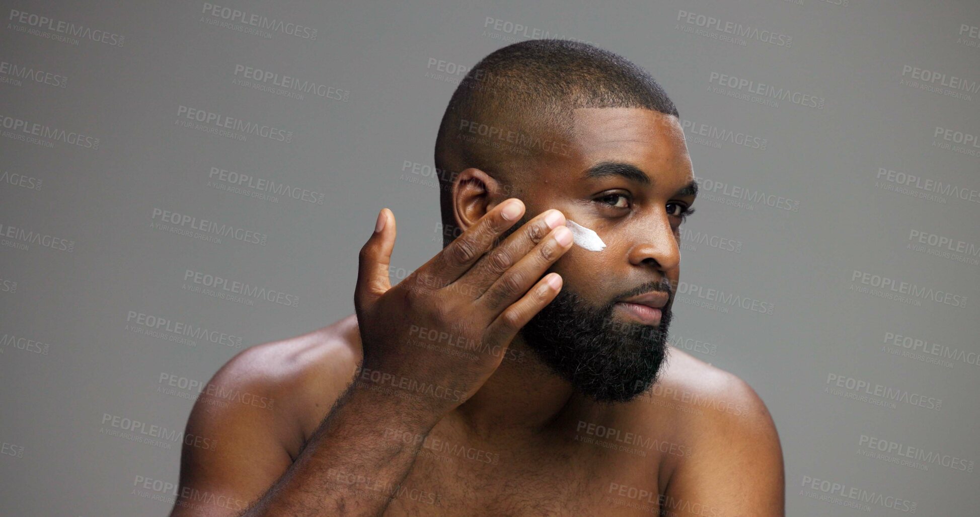 Buy stock photo Beauty, skincare and cream with black man in studio for salon, grooming and dermatology. Cosmetics, glow and self care with person and lotion on gray background for hydration, hygiene and shine