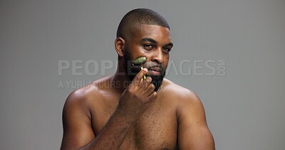 Buy stock photo Black man, portrait or skincare in studio with roller or product for facial massage on grey background. Face, crystal stone treatment or model with dermatology cosmetic, beauty glow or mockup space