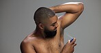 Grooming, studio and man with spray, armpit and self care with product for smell, smile and fragrance. Gray background, happy and black person with cosmetics for hygiene, space and scent for underarm