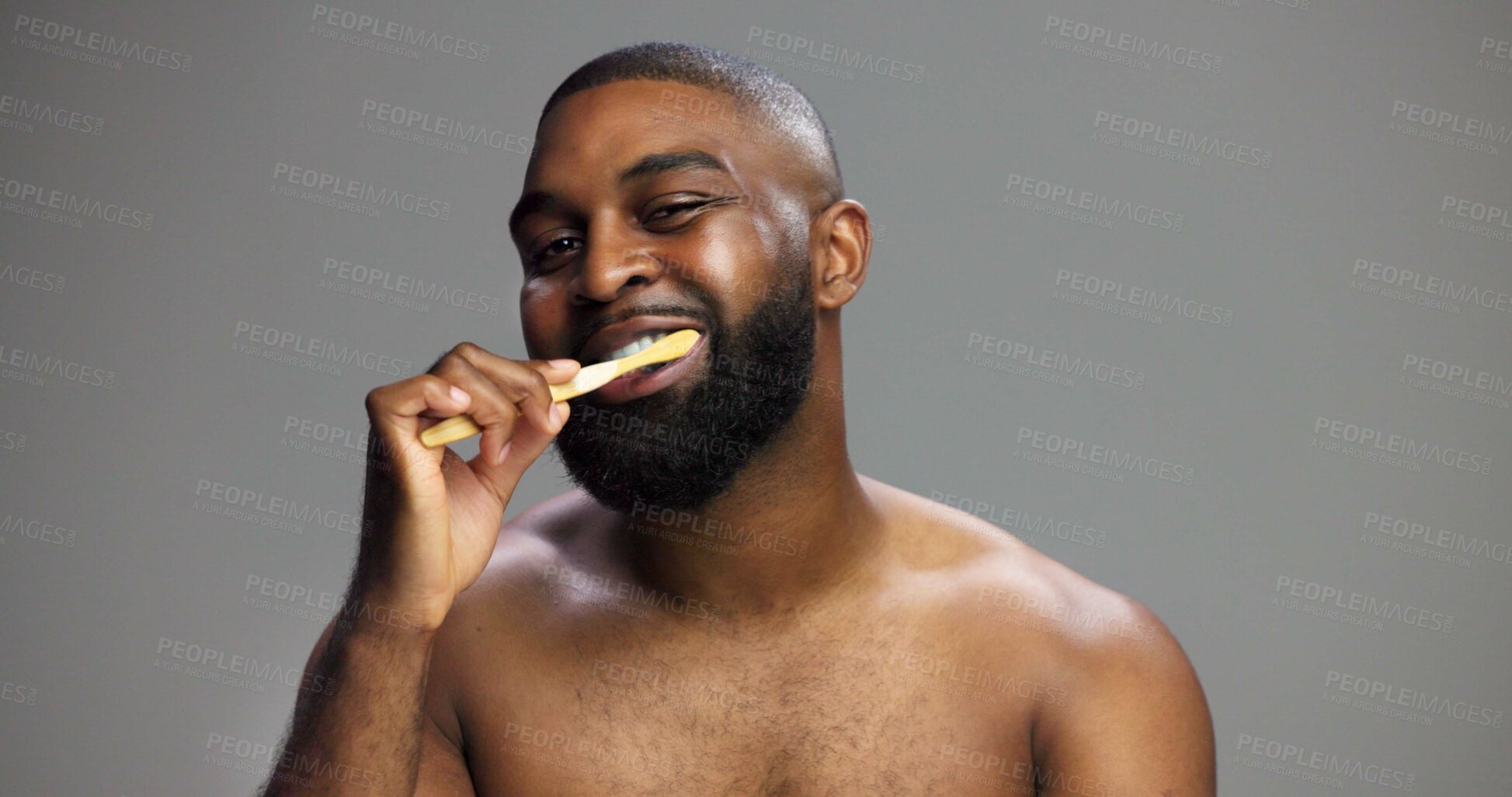 Buy stock photo Toothbrush, smile and black man in studio for hygiene, fresh breath and mockup in morning. Portrait, wellness and person brushing teeth for dental care, cleaning or grooming on grey background space
