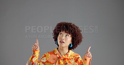 Buy stock photo Woman, pointing up in studio and fashion announcement, notice or information with retro style promo. Ads, mockup or space for news, afro person or vintage clothes coming soon on gray background