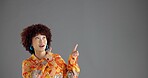Woman, pointing up in studio and fashion information, notice or announcement with retro style promo. Ads, mockup or space for news, afro person or vintage clothes coming soon on gray background