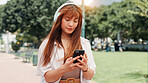 Park, walking and woman with headphones, phone or search online for streaming service on college campus. Outdoor, connection and university student girl with smartphone, music or podcast subscription