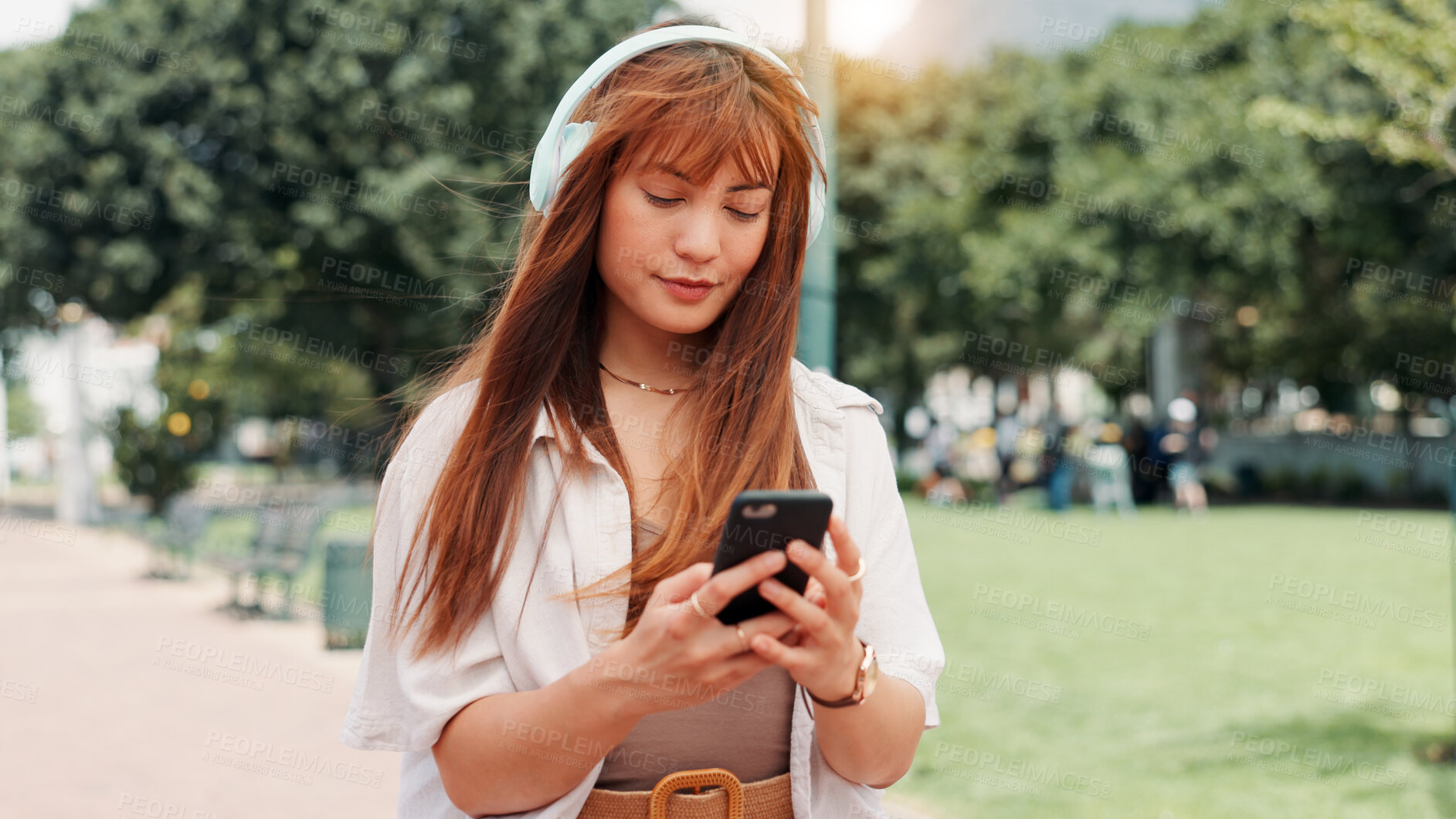 Buy stock photo Park, walking and woman with headphones, phone or search online for streaming service on college campus. Outdoor, connection and university student girl with smartphone, music or podcast subscription