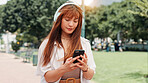 Park, walking and woman with headphones, phone or search online for streaming service on college campus. Outdoor, connection and university student girl with smartphone, music or podcast subscription