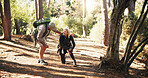 Senior, couple and hiking with help for knee pain, injury or accident with support or wellness check. Travel, concern and man with woman for trekking fall, care or aid with sprain outdoor in forest