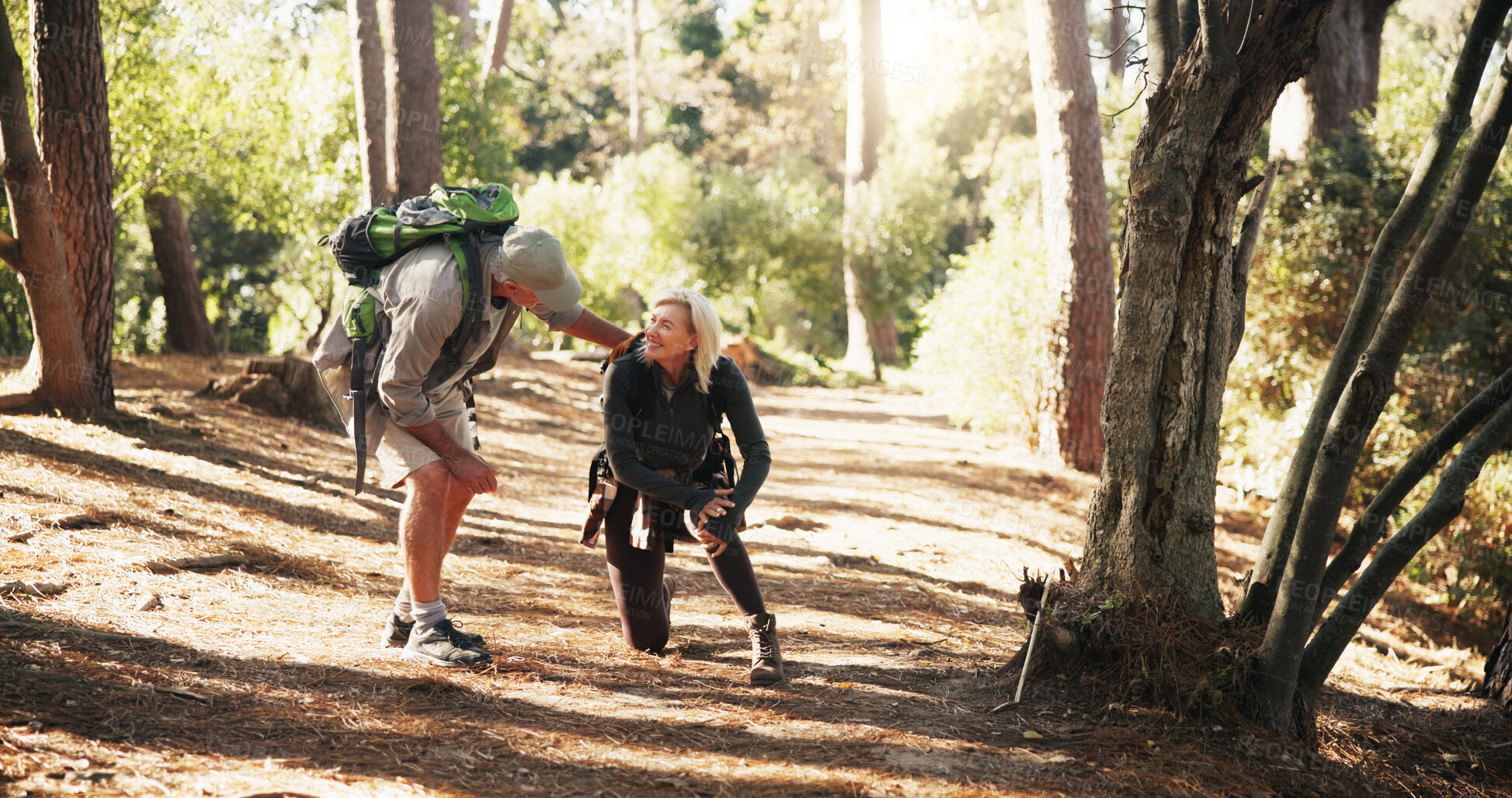 Buy stock photo Senior, couple and hiking with help for knee pain, injury or accident with support or wellness check. Travel, concern and man with woman for trekking fall, care or aid with sprain outdoor in forest