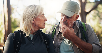 Buy stock photo Senior couple, hiking and talking for route direction and tourism on holiday with travel decision. People, retirement and hikers in discussion for planning, trekking or outdoor adventure in woods