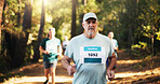 Competition, marathon and mature man in forest for challenge, performance or race. Cardio, fitness and running with athlete at outdoor event or rally in nature or woods for course, heat and trial