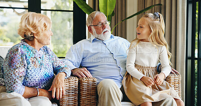 Buy stock photo Family, grandparents and child with smile, home and talking to granddaughter in living room or chat. Happy, elderly man and old woman with girl in lounge, together and senior people with kid in house