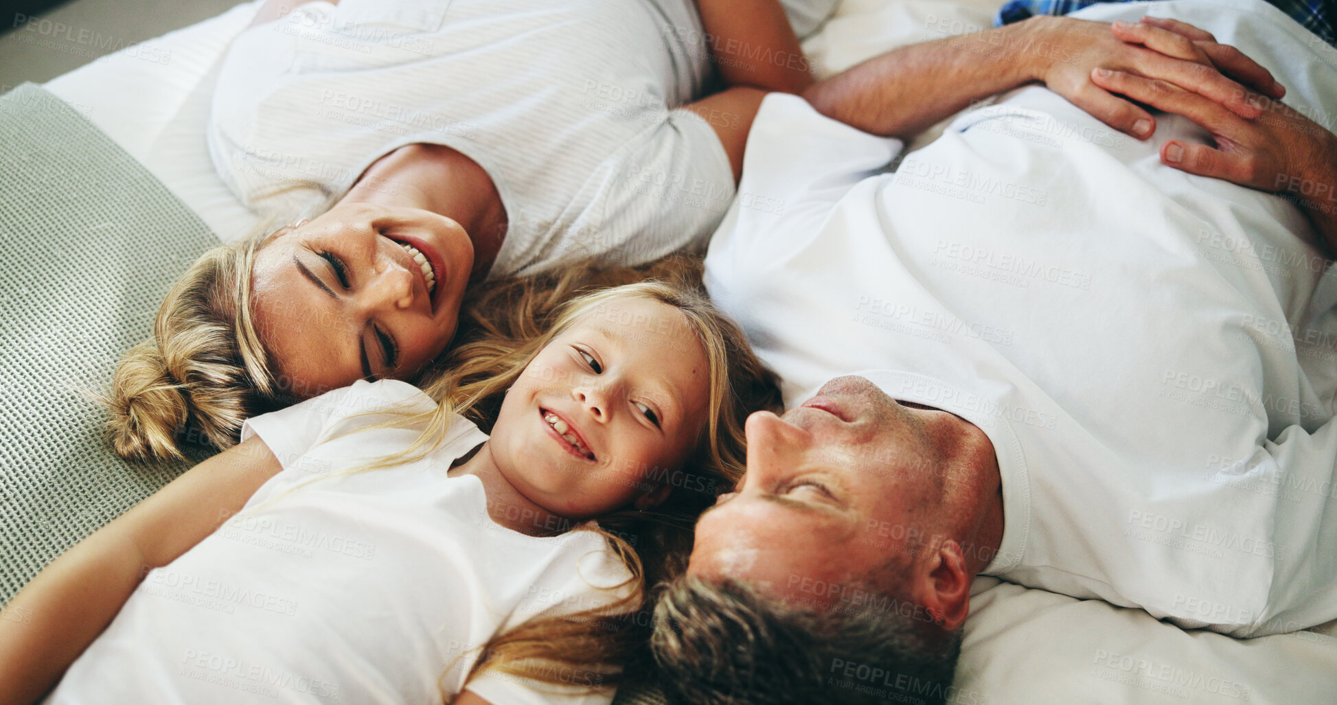 Buy stock photo Smile, parents and child relax on bed with love, security and bonding together in bedroom. Happy, people and resting with girl for support, care and family relationship for weekend break at house
