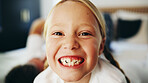 Happy girl, portrait and child on bed for weekend, morning or youth day in joy at home. Face, teeth or friendly kid with smile in relax for comfort, positive attitude or holiday in bedroom at house
