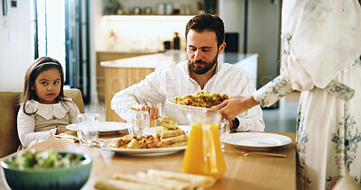 Buy stock photo Muslim, family and serving food at house for Eid lunch, healthy meal and feast for celebration. Parents, man and child eating with dish for nutrition, religious event and cuisine of Islam culture