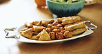 Culture, food and eid Mubarak with dish on table dining room for nutrition, samosa and Islamic festival celebration. Muslim holiday event, Ramadan iftar and closeup of meal at home for raya feast