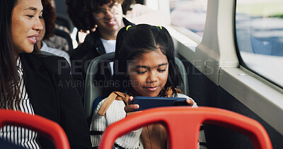 Buy stock photo Girl, child and play with phone on bus for entertainment, online streaming or watching in vehicle with mom. Kid, traveler and smile with smartphone in public transport for movie subscription app
