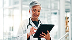 Mature woman, doctor and research with tablet for medical discovery, news or healthcare service at hospital. Female person, health worker or executive browsing with technology for telehealth or app