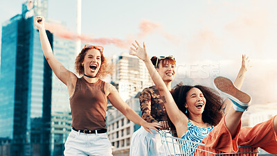 Buy stock photo Friends, girls with trolley in city laughing for funny adventure, playing and bonding on sidewalk. Excited, color smoke or women pushing cart in urban town with freedom, confidence and weekend break
