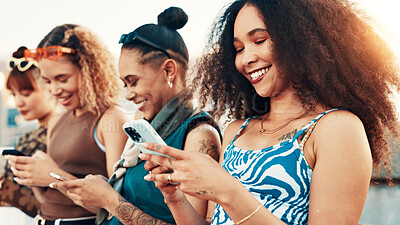 Buy stock photo City, smile and group of friends with smartphone, gen z fashion or online application for gossip. Urban, cool style and women in row with technology for network, social media or chat on internet post