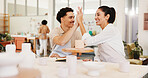 Pottery class, high five and friends in ceramic workshop with help, achievement and clay product. Advice, woman and man in studio with support, feedback and sculpture design mold or smile for lesson