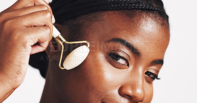 Buy stock photo Skincare, black woman or face roller in studio for lymphatic drainage, blood circulation or puffiness reduction. Natural beauty, portrait or girl with quartz for radiant skin on white background