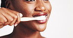 Hands, brushing teeth and mouth in studio for dental protection, cleaning and self care by white background. Girl, model and bamboo toothbrush with toothpaste, foam and routine with oral wellness
