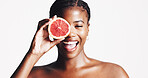 Happy, black woman and portrait with grapefruit for skincare, detox or vitamin C on a white studio background. Female person, model or smile with natural organic fruit for facial treatment on space