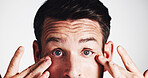 Man, studio and stress with eye irritation on white background with infection, glaucoma and concern. Contact lenses, portrait and person frown with reaction to allergy, vision loss or retina wellness