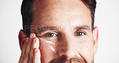 Buy stock photo Cream, eyes and beauty with man in studio for anti aging, dermatology and collagen product. Skincare, wrinkle treatment and lotion with closeup of person on white background for cosmetics and facial