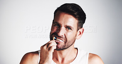 Buy stock photo Portrait, man and brushing teeth for hygiene in studio for dental care, fresh breath and oral health. Male person, toothbrush and treatment for plaque removal, whitening benefits and white background