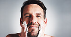 Man, portrait and shaving cream in studio with smile, grooming or hygiene with pride by background. Mature person, beard and foam for routine, self care or process for facial hair removal in Portugal